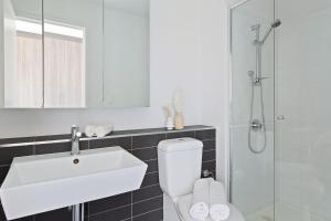 a bathroom with a toilet and a sink and a shower at A Modern 2BR Apt with Harbour Views FREE Parking in Melbourne