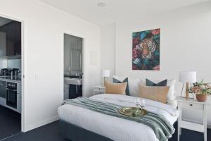 a bedroom with a bed with a table on it at A Modern 2BR Apt with Harbour Views FREE Parking in Melbourne