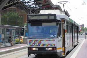 a bus is parked at a bus stop at A Modern 2BR Apt with Harbour Views FREE Parking in Melbourne