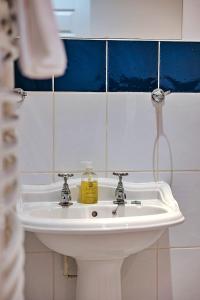 a bathroom sink with a bottle of soap on it at Finest Retreats - Netley Hall - Peach Tree in Dorrington