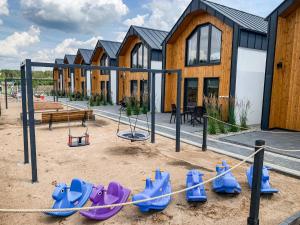 a playground with blue and purple equipment in front of a building at Skorzęcin Rybakówka Resort in Skorzęcin
