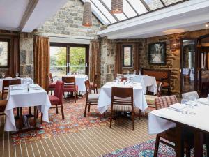 un comedor con mesas y sillas blancas en Mercure Barnsley Tankersley Manor Hotel, en Barnsley