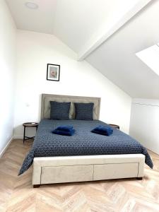Un dormitorio con una cama con almohadas azules. en Magnifique Appartement Neuf, 5 Min Orly - Climatisé, en Paray-Vieille-Poste