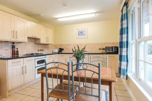 eine Küche mit weißen Schränken und einem Holztisch in der Unterkunft Finest Retreats - Netley Hall - Lavender in Dorrington