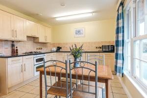 a kitchen with white cabinets and a wooden table at Finest Retreats - Netley Hall - Lavender in Dorrington