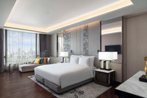1 dormitorio con 1 cama blanca grande y 1 sofá en Sindhorn Kempinski Hotel Bangkok - SHA Extra Plus Certified, en Bangkok