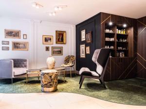 a living room with two chairs and a table at Aigle Noir Fontainebleau MGallery in Fontainebleau