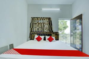 a bedroom with a large bed with red pillows at Flagship Hotel Pragya 3 New in Raipur