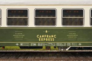 un vagón de tren verde y blanco en las vías en Canfranc Estación, a Royal Hideaway Hotel - Gran Lujo, en Canfranc-Estación
