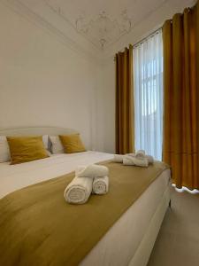 una camera da letto con un grande letto con asciugamani di Cutelli Gold a Catania