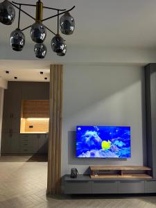 sala de estar con TV de pantalla plana en la pared en Modern Family Comfort: Yerevan/Wi-Fi, Balcony, AC, en Ereván