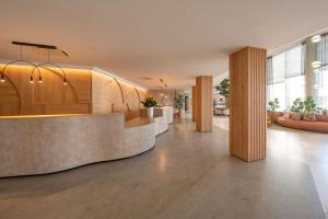 a lobby with wooden columns and a reception desk at DoubleTree by Hilton Malta in St Paul's Bay