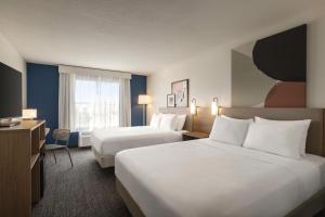 a hotel room with two beds and a television at Spark by Hilton Orlando Universal Blvd in Orlando