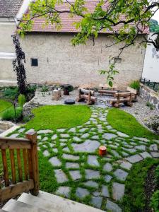 a garden with two benches and a stone patio at Penzion Pršutérie® in Litoměřice