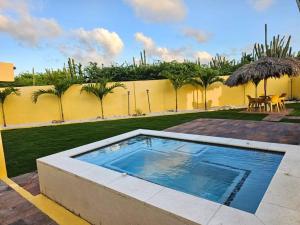 a swimming pool in the middle of a yard at Yellow Cunucu-4 Bedrooms House in Paraguaná