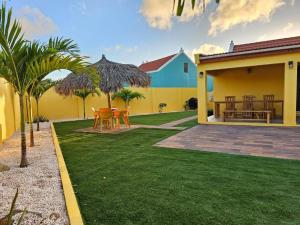 a house with a yard with a table and chairs at Yellow Cunucu-4 Bedrooms House in Paraguaná