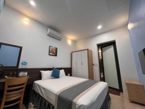 Habitación de hotel con cama, escritorio y cama sidx sidx en Happy House Moc Chau, en Mộc Châu