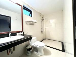 een badkamer met een toilet, een wastafel en een spiegel bij Happy House Moc Chau in Mộc Châu