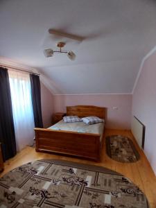 a bedroom with a bed and a rug on the floor at На Пагорбі in Mykulychyn