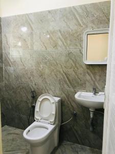 een badkamer met een toilet en een wastafel bij NABA HOME STAY OOTY in Ooty