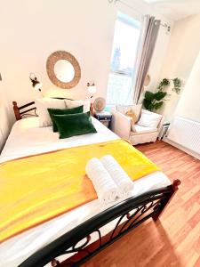 um quarto com uma cama grande com lençóis amarelos e verdes em Always the same price! Free parking em Londres
