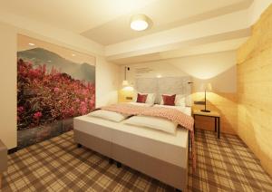 ein Schlafzimmer mit einem Bett und einem Wandgemälde in der Unterkunft Ruhpoldinger Hof in Ruhpolding