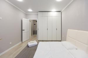 1 dormitorio blanco con 1 cama grande y armarios blancos en Уютная двухкомнатная квартира в центре города en Kokshetau