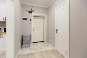 a hallway with white walls and a white door at Уютная двухкомнатная квартира в центре города in Kokshetau