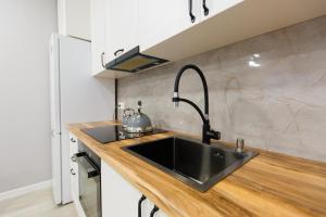 cocina con fregadero negro y encimera en Уютная двухкомнатная квартира в центре города en Kokshetau