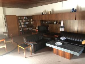 ein Wohnzimmer mit einem schwarzen Ledersofa und einem Tisch in der Unterkunft Haus Diepholz in Diepholz