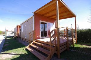 een huis met een veranda en een terras bij Camping Verona Village in Verona