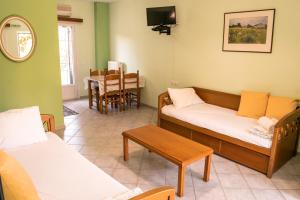 a living room with two beds and a table at Chrisanthi Apartments in Syvota