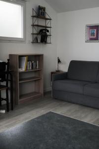 ein Wohnzimmer mit Sofa und Bücherregal in der Unterkunft GuestReady - Monochromatique near the port in La Rochelle