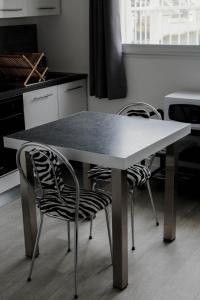 een keuken met een tafel met 2 stoelen en een aanrecht bij GuestReady - Monochromatique near the port in La Rochelle