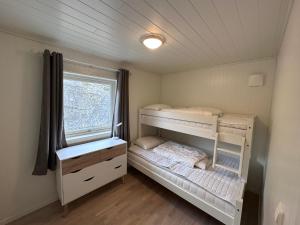 1 Schlafzimmer mit 2 Etagenbetten und einem Fenster in der Unterkunft Moderne feriehus i Bud in Bud