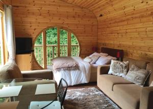 a living room with a bed and a couch at Herons Lake Retreat in Caerwys