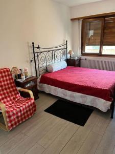 a bedroom with a red bed and a chair at Chambre double privée, Appartement partagé in Annemasse