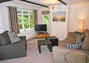 a living room with two couches and a flat screen tv at Herons Lake Retreat in Caerwys