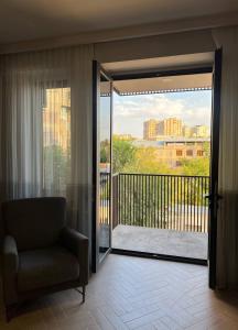 una sala de estar con una puerta que da a un balcón en Modern Family Comfort: Yerevan/Wi-Fi, Balcony, AC, en Ereván