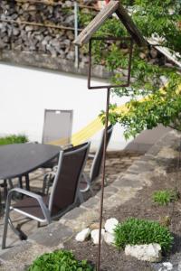 a bird feeder in a garden with chairs and a table at Landwohnung in Lingenau