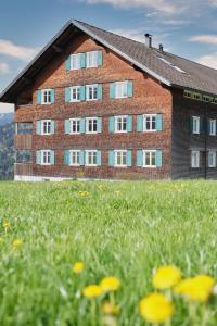 a building with a field of flowers in front of it at Landwohnung in Lingenau