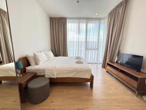 una camera d'albergo con letto e TV di 2 Bedroom Beachfront Apartment With Sea Views a Mai Khao Beach