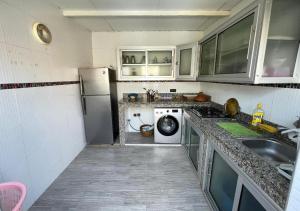 una cucina con frigorifero, lavatrice e asciugatrice di Sun Hostel a Marrakech