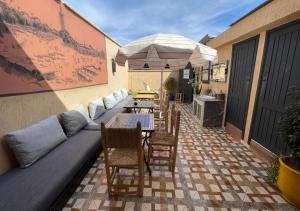 patio con divano, tavoli e ombrellone di Sun Hostel a Marrakech