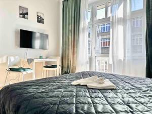 1 dormitorio con cama y ventana grande en Powstańców 22' Street Apartamenty i Pokoje en Katowice