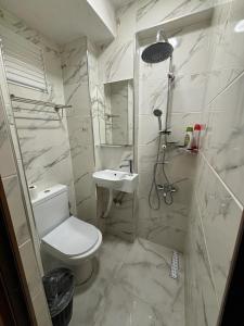 a white bathroom with a toilet and a sink at Hotel Wiva in Istanbul