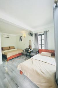 ein Hotelzimmer mit 2 Betten und einem Schreibtisch in der Unterkunft Luti Homestay and Restaurant in Dong Hoi
