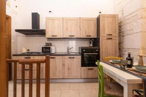 a kitchen with wooden cabinets and a counter top at Casa Sea La Vie in Ostuni