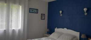 a blue bedroom with a bed and a window at Maison classée 2*, 6 personnes, animal accepté, mer 300m in Soulac-sur-Mer