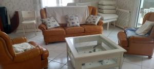 a living room with a couch and two chairs at Maison classée 2*, 6 personnes, animal accepté, mer 300m in Soulac-sur-Mer